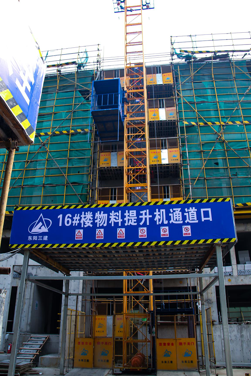 Fix one column and two cages with a construction material elevator on the construction site. Safety of construction elevators for preventing falling, single occupancy, and double cages